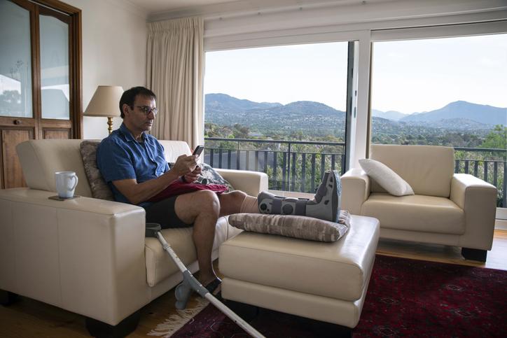 Injury at home Man with broken leg rehabilitating at home