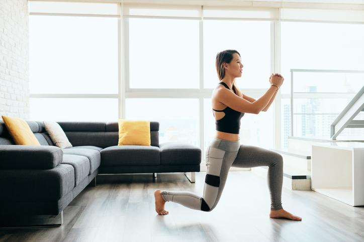 Female working out at home with lunges exercise Female working out at home with lunges exercise