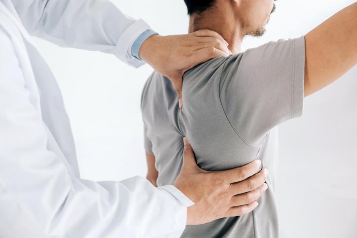 Male patient having scapular trigger point release therapy Male patient having scapular trigger point release therapy