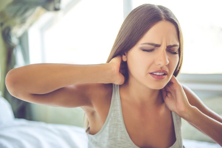 Neck pain Lady getting out of bed with neck pain
